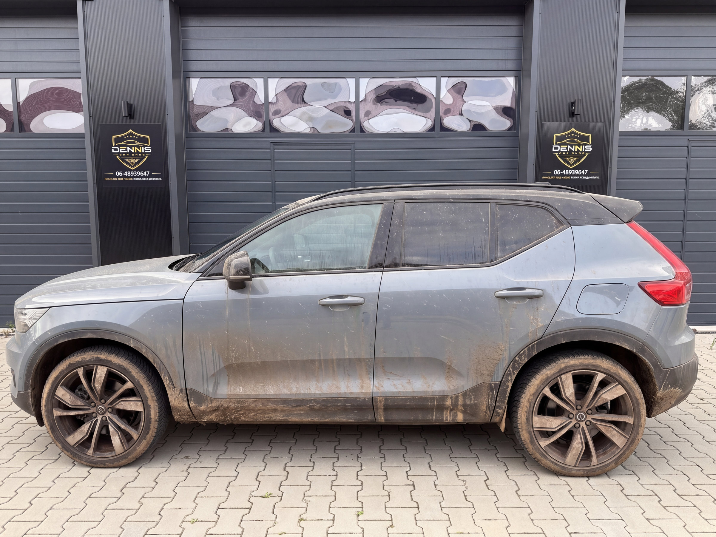 Grijze SUV onder het vuil voor de werkplaats