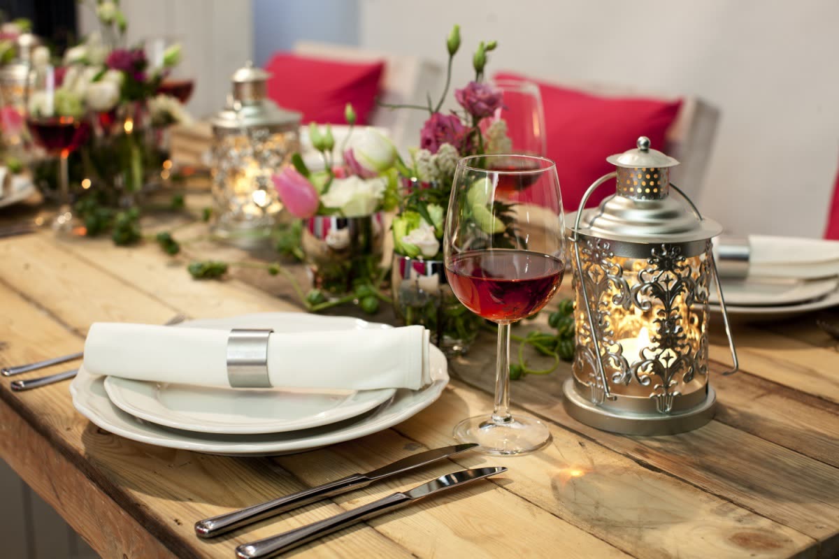 Gedekte tafel met steigerhout, servies en lantaarns