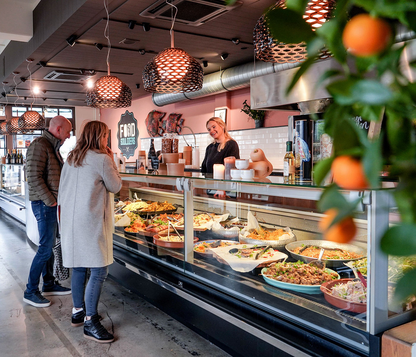 Klanten aan de toonbank met de volle vitrine van FoodSouldiers