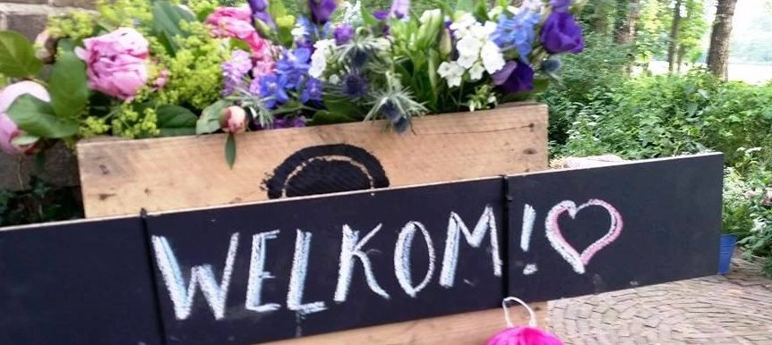 Krijtbord met de tekst Welkom bij een bloemstuk van Hapjesgigant