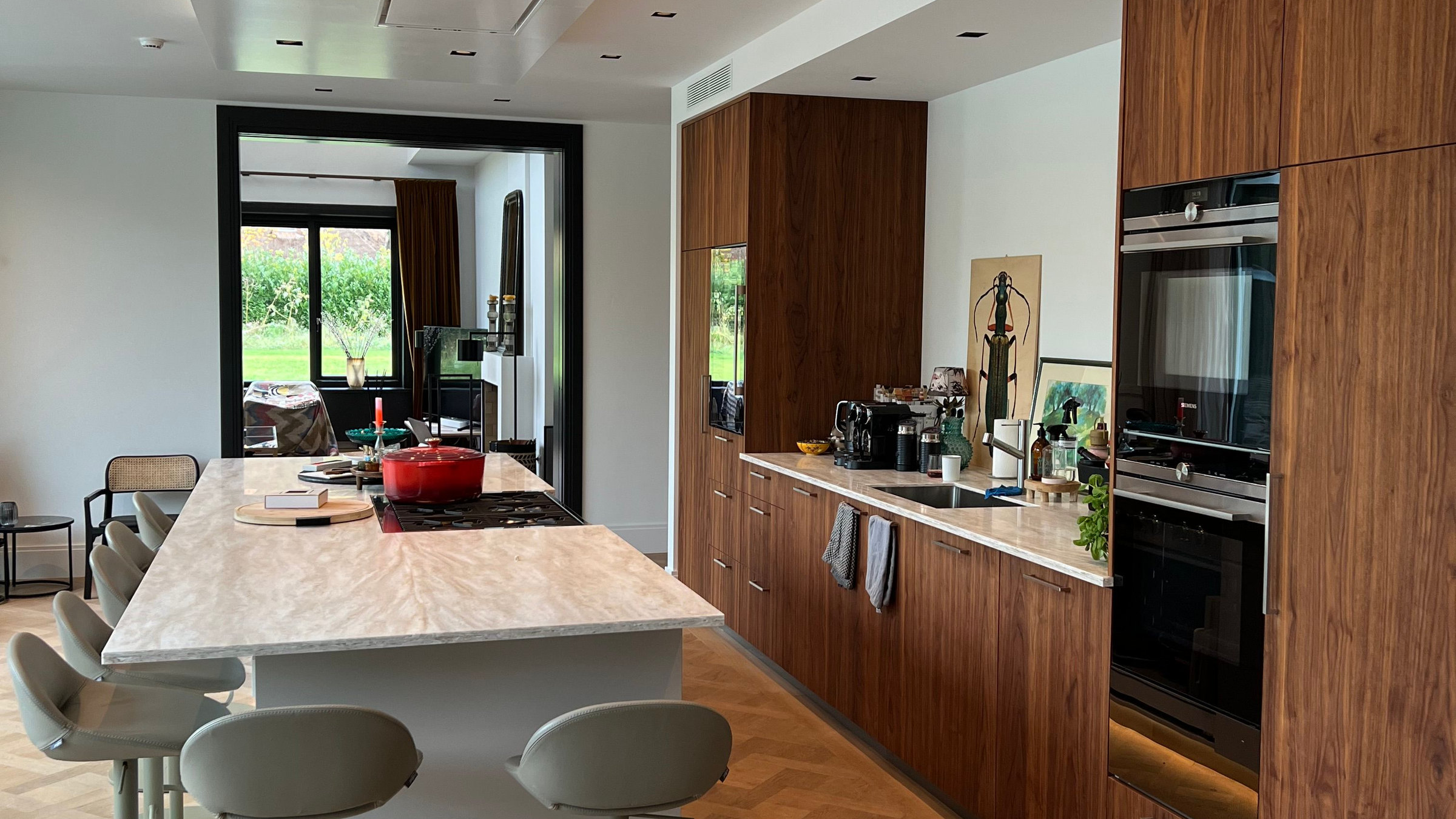 Open keuken in noten met warme cove-verlichting en doorkijk